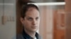 FILE - Wall Street Journal reporter Evan Gershkovich stands in a glass cage in a courtroom at the Moscow City Court in Moscow, Russia, on Oct. 10, 2023. 