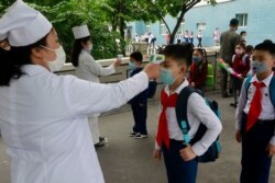 资料照：朝鲜首都平壤一所小学的学生带着口罩接受体温检测。（2020年6月3日）