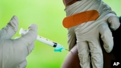 FILE - A health worker administers a dose of a COVID-19 vaccine during a vaccination clinic at the Reading Area Community College in Reading, Pennsylvania, Sept. 14, 2021. 