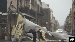 A man passes by a section of roof that was blown off of a building in the French Quarter by Hurricane Ida winds, Sunday, Aug. 29, 2021, in New Orleans. (AP Photo/Eric Gay)