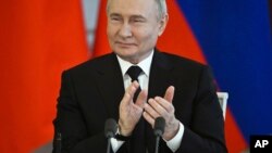 Президент Росії Володимир Путін аплодує під час підписання договору із спадкоємним принцом і прем’єр-міністром Бахрейну Салманом бін Хамадом бін Ісою Аль Халіфою в Кремлі, Росія, 23 травня 2024 р. Sergei Guneyev, Sputnik, Kremlin Pool Photo via AP
