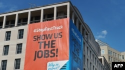 Banners declaring opposition to President Barack Obama's bid for trade legislation are seen on the headquarters of the American Federation of Labor and Congress of Industrial Organizations in Washington, June 12, 2015.