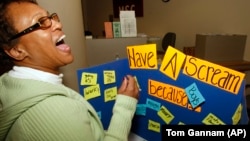 Transfer student Tina Wright, a senior in Criminology, lets out a scream after adding her reason to scream on the board at a "Stress Blowoff" event at the student union on the University of Missouri in St. Louis.