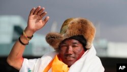 FILE - In this May 20, 2018, file photo, Nepalese veteran Sherpa guide, Kami Rita, 48, waves as he arrives in Kathmandu, Nepal. Rita has scaled Mount Everest for a 23rd time, breaking his own record for the most successful ascents. (AP Photo/Niranjan Shrestha, File)