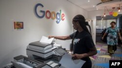Mwanamke akitumia mashine ya photocopy katika ofisi ya Google Artificial Intelligence (AI) huko Accra Aprili 10, 2019. - Hiki ni kituo cha kwanza cha AI kufunguliwa Afrika na kampuni ya Google. (Photo by CRISTINA ALDEHUELA / AFP)