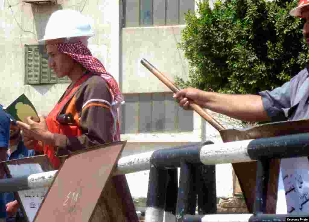 Egypt's Muslim Brotherhood holding Qurans and sticks at the security checkpoint entering the Muslim Brotherhood stronghold outside Cairo's Rabaa al-Adawiya mosque, July 11. Photo: VOA/Sharon Behn