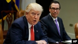 FILE - Treasury Secretary Steven Mnuchin listens at right as President Donald Trump speaks during a meeting on the Federal budget, Feb. 22, 2017, in the Roosevelt Room of the White House in Washington.