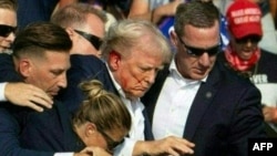 Ứng cử viên Đảng Cộng hòa Donald Trump được lực lượng Mật vụ đưa ra khỏi sân khấu sau khi ông bị thương trong một vụ nổ súng, tại một sự kiện vận động tranh cử ở Butler, bang Pennsylvania, ngày 13 tháng 7 năm 2024.