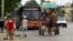 Residentes de La Habana, Cuba, usan un coche tirado por caballos y un autobús el 12 de septiembre de 2019.