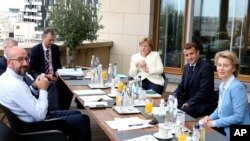 European Council President Charles Michel, left, poses for photographers with German Chancellor Angela Merkel, third right, French President Emmanuel Macron, second right and European Commission President Ursula von der Leyen.