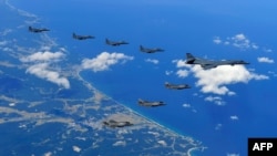 This picture provided by the SOuth Korean Defense Ministry shows a US Air Force B-1B Lancer bomber (R), US F-35B stealth jet fighters (bottom) and South Korean F-15K fighter jets (top) flying over South Korea during a joint military drill aimed to counter North Korea’s latest nuclear and missile tests. The US flew four stealth fighter jets and two bombers over the Korean peninsula on September 18 (Credit: AFP PHOTO / South Korean Defence Ministry handout).