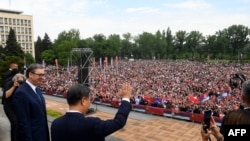 На фотографијата од прес-службата на претседателот на Србија, кинескиот претседател Шји Џинпинг со српскиот претседател Александар Вучиќ ја поздравува толпата пред Палатата Србија за време на церемонијата за пречек во Белград, 8 мај 2024 година.