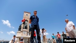 A man stands during a silent protest in Taksim Square in Istanbul June 18, 2013. 