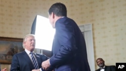 Le président Donald Trump, à gauche, salue l’ancien directeur du FBI James Comey lors d’une rencontre au Blue Room, à la Maison Blanche, Washington, 22 janvier 2017.