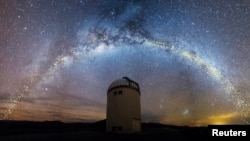  The warped shape of the stellar disk of the Milky Way is seen over the Warsaw University Telescope at Las Campanas Observatory, Chile, in an artist's rendition, Aug. 1, 2019. (Jan Skowron/University of Warsaw)