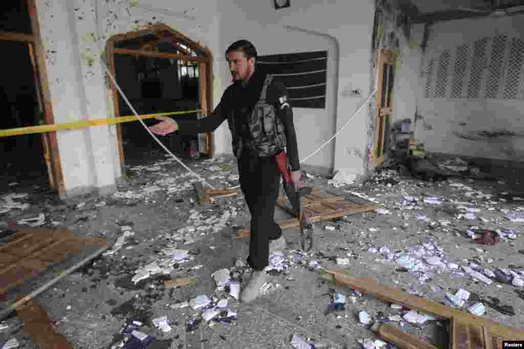 A security officer surveys damage after an explosion in a Shi'ite mosque in Peshawar, Feb. 13, 2015.