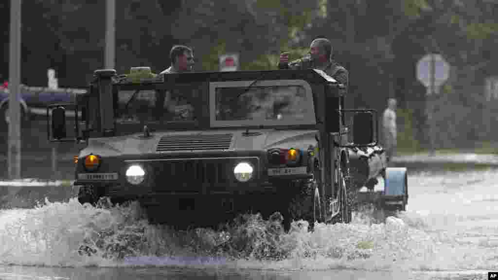 Une voiture de la Garde nationale traverse l'eau, le 14 août 2016.