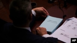 香港一名立法會議議員手持香港國安法。 （2024年3月19日）