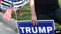 A supporter of US President Donald Trump holds a sign to show their support before the vice presidential debate outside Kingsbury Hall at the University of Utah on October 7, 2020, in Salt Lake City, Utah. (Photo by GEORGE FREY / AFP)