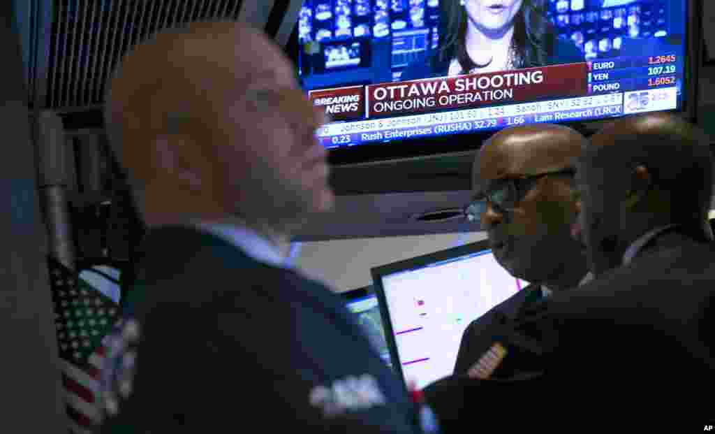 A television on the floor of the New York Stock Exchange features a headline about the shooting in Ottawa. Stocks fell in late afternoon trading on Wednesday, a day after the Standard &amp; Poor's 500 index had its biggest gain of the year, Oct. 22, 2014. 