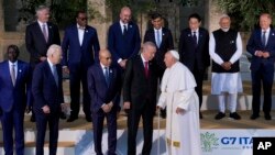 Presiden AS Joe Biden bersama sejumlah pemimpin negara-negara G7 dan Paus Fransiskus bersiap untuk foto bersama dalam pertemuan puncak kelompok negara maju itu di Borgo Egnazia, Italia, 14 Juni 2024. (Foto: Luca Bruno/AP Photo)