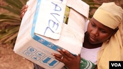 A woman helps load relief supplies onto a truck bound for northern Mali, April 13, 2012. (N. Palus/VOA)