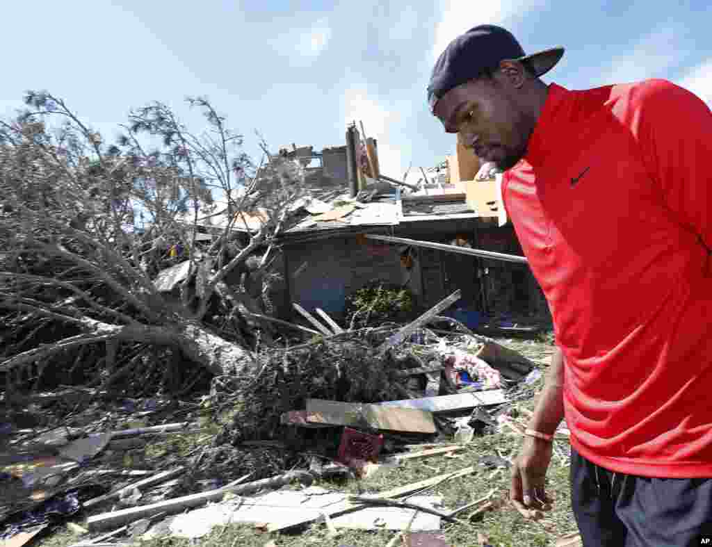 Oklahoma City Thunder NBA basketball player Kevin Durant walks past tornado-damaged homes in a neighborhood in Moore, Oklahoma, May 22, 2013. 