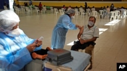 Trabajadores de la salud administran vacunas contra el COVID-19 a guatemaltecos en Ciudad Guatemala, la capital, en julio de 2021.
