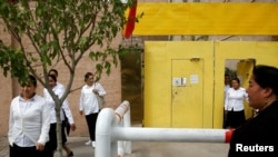 ស្ត្រី​ជនជាតិ​អ៊ុយហ្គួរ​ចាកចេញ​ពី​មជ្ឈមណ្ឌល​មួយ​ដែល​គេ​បង្រៀន​មេរៀន​នយោបាយ​នៅ​ក្នុង​ក្រុង Kashgar តំបន់ Xinjiang ប្រទេស​ចិន​ កាលពី​ថ្ងៃទី៦ ខែកញ្ញា ឆ្នាំ២០១៨។ 