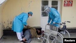 Trabajadores de salud en La Paz, Bolivia, ayudan a un hombre que yace en la calle en medio del brote del nuevo coronavirus, el 23 de julio de 2020.