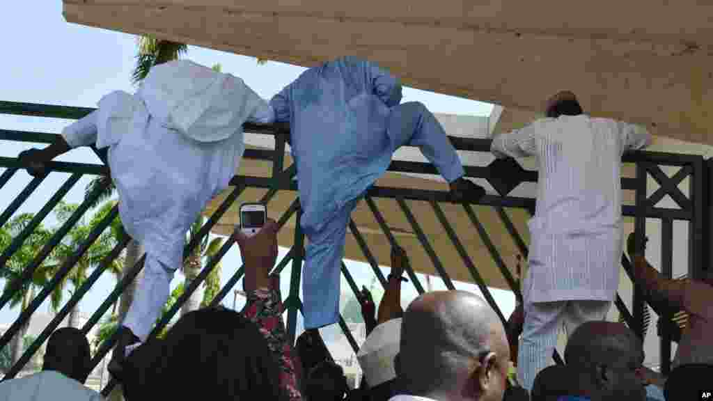 Wasu 'yan majalisa suna hawar katangar harabar majalisar domin su shiga zauren taronsu, Nuwamba 20, 2014.