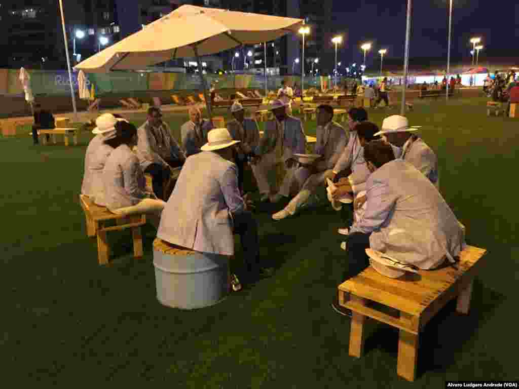 Reunidos reflectindo sobre os jogos no cair da noite. Vila Olímpica, Rio de Janeiro, Jogos Olímpicos 2016, Brasil