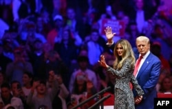 Mantan Presiden AS dan calon presiden dari Partai Republik Donald Trump dan istrinya, mantan Ibu Negara AS Melania Trump melambaikan tangan di Madison Square Garden di New York, 27 Oktober 2024. (Foto: AFP)