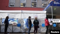 Una fila de personas espera para recibir la segunda dosis de la vacuna contra COVID-19 en un hospital de Manhattan, Nueva York, el 29 de marzo de 2021.