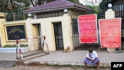 FILE - A man sits in front of Insein prison in Yangon on April 12, 2021, while waiting to visit inmates ahead of the long holiday stretch for the Myanmar New Year, also known as Thingyan, as the country remains in turmoil after the February military coup.