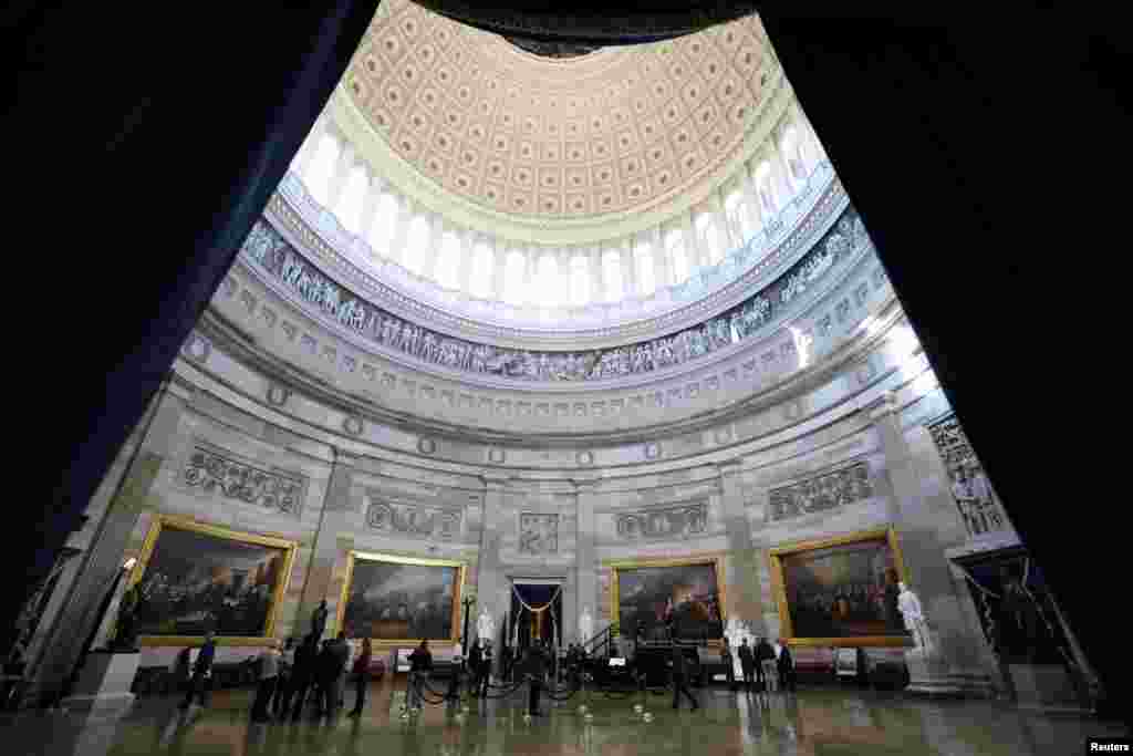 People stand in the rotunda where the inaugural address will take place after it was announced President-elect Donald Trump's inauguration is being moved indoors due to dangerously cold temperatures expected on Monday, in Washington.