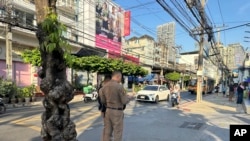 ตำรวจยืนอยู่ด้านนอกของศูนย์ควบคุมตัวชาวอุยกูร์ที่ถูกจับในกรุงเทพมหานคร 11 ม.ค. 2025 (AP Photo/Haruka Nuga)