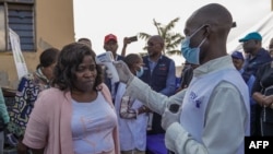 Afisa wa serikali akichukua vipimo vya joto wakati wa uzinduzi wa kampeni ya chanjo ya mpox huko DRC October 5, 2024. Picha na AFP 