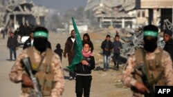 ခန်ယူနစ်မြို့က ဓားစာခံလဲလှယ်ကြမဲ့နေရာနားမှာ ပါလက်စတိုင်းဟာမတ်တိုက်ခိုက်ရေးသမားတွေ လုံခြုံရေးယူနေစဥ်။ (ဇန်နဝါရီ ၃၀၊ ၂၀၂၅) 