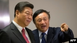 FILE - Chinese President Xi Jinping, left, is shown around the offices of Chinese tech firm Huawei technologies by its President Ren Zhengfei in London during his state visit, Oct. 21, 2015.