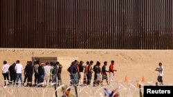 ជនចំណាកស្រុកប្រមូលផ្តុំគ្នានៅក្បែរជញ្ជាំងព្រំដែនរវាងប្រទេសម៉ិកស៊ិក និងសហរដ្ឋអាមេរិក កាលពីថ្ងៃទី ៥ ខែតុលា ឆ្នាំ ២០២៣។ 