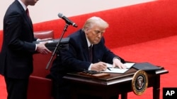 ปธน.โดนัลด์ ทรัมป์ ลงนามในคำสั่งฝ่ายบริหารขณะเข้าร่วมกิจกรรมพาเหรดฉลองการปฏิญาณตนเข้ารับตำแหน่งที่สนามกีฬา แคปิตอล วัน อารีนา ในกรุงวอชิงตัน เมื่อวันจันทร์ที่ 20 ม.ค. 2568