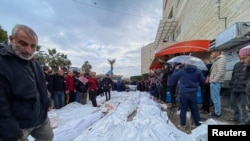 Los dolientes reaccionan junto a los cuerpos de los palestinos muertos en ataques israelíes en un hospital en el centro de la Franja de Gaza, el 25 de diciembre de 2023. 