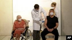 La veterana de la Segunda Guerra Mundial Emilie Repikova observa al primer ministro de la República Checa, Andrej Babis, recibir la vacuna contra la COVID-19, en Praga, el domingo 27 de diciembre de 2020.