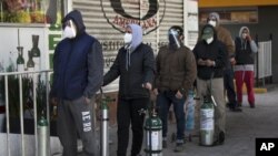 Orang-orang antre mengisi ulang tabung oksigen untuk kerabat yang menderita COVID-19 di luar sebuah toko penjual oksigen di Mexico City, 31 Desember 2020. (Foto: AP Photo/Marco Ugarte)