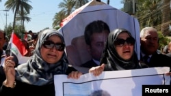 FILE - Iraqi journalists carry a mock coffin at a symbolic funeral for Mohammed Badawi, the Baghdad bureau chief of Radio Free Iraq, in Baghdad's Jadriyah district, March 23, 2014.