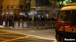 រូបឯកសារ៖ ក្រុមអ្នកគាំទ្រ​សកម្មជនគាំទ្រលទ្ធិ​ប្រជាធិបតេយ្យ បញ្ចាំងពិល គ្រាដែល​រថយន្ត​ដឹក​អ្នកទោស ដឹក​សកម្មជន​គាំទ្រ​លទ្ធិ​ប្រជាធិបតេយ្យ​ចំនួន​៤៧នាក់ ដែល​ត្រូវបាន​ចោទ​ប្រកាន់​ក្រោម​ច្បាប់​សន្តិសុខ​ជាតិ ទៅ​ដល់​មជ្ឈមណ្ឌល Lai Chi Kok នៅ​ទីក្រុង​ហុងកុង កាលពី​ថ្ងៃទី៤ ខែមីនា ឆ្នាំ២០២១។