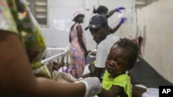 A child injured by the recent 7.2 magnitude earthquake is treated at the Immaculee Conception hospital in Les Cayes, Haiti, Thursday, Aug. 19, 2021. (AP Photo/Joseph Odelyn)