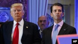 FILE - In this Jan. 11, 2017, shows President-elect Donald Trump, left, his chief financial officer Allen Weisselberg, center, and his son Donald Trump Jr., right, attend a news conference in the lobby of Trump Tower in New York. Manhattan prosecutors hav