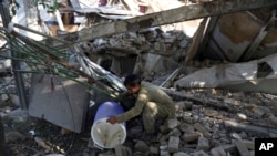 An Afghan man searches for belongings at his shop after an attack in Kabul, July 2, 2019. The Taliban set off a powerful bomb in Kabul, killing a several people. The Afghan Taliban and the U.S. paused peace talks for a day on July 5 in Qatar.